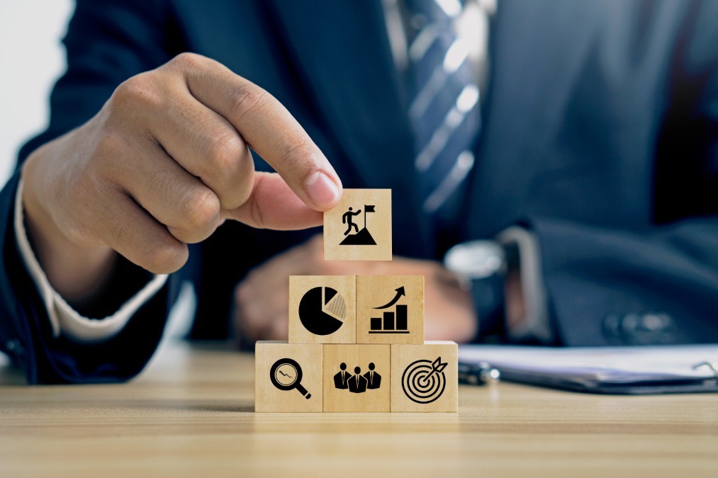 Manager empilant des cubes représentant la hiérarchie des indicateurs de performance RH