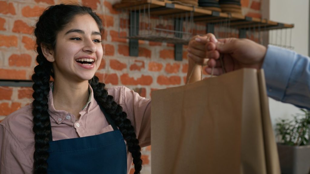 Agence web Toulouse : un commerçant toulousain échange avec une cliente satisfaite dans sa boutique.